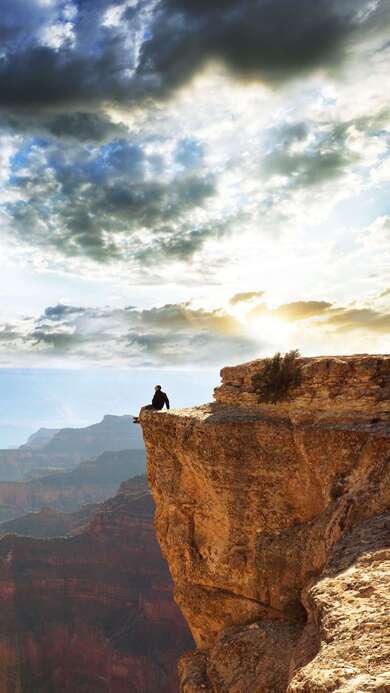 Alone Boy Sitting at Top of Mountain