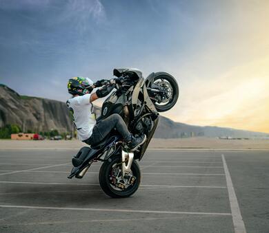 Biker Performing Trick on Motorbike on Road