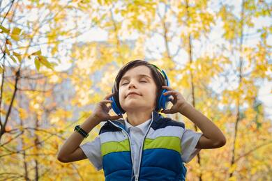 Boy Listing Music And Yellow Trees in Background