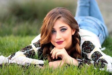 Girl With Crystal Eves Lying on Green Grass