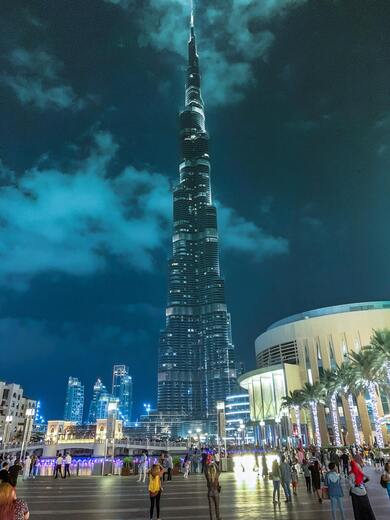 People Standing Near High rise Building During Night Time