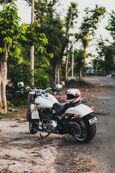 White Harley Davidson Fatboy Cruiser Motorcycle With Helmet on Seat