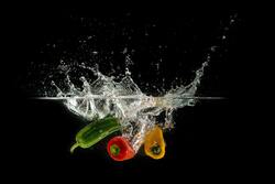 Colorful Chillies in Water Black Background Wallpaper