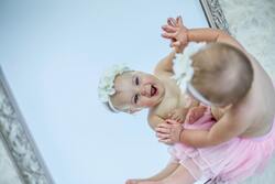 Cute Baby Girl Looking in Mirror and Smiling