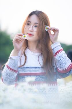 Cute Korean Girl in Glasses With Flower in Hands