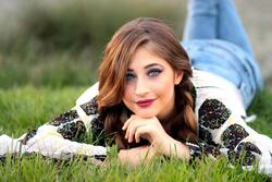 Girl With Crystal Eves Lying on Green Grass