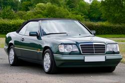 Green Mercedes Benz Coupe on Gray Asphalt Road