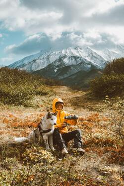 Man And Dog Sitting Together on Mountain