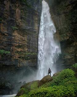Man Standing Near Big Waterfall