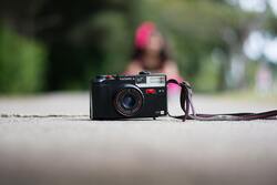 Mini Camera on Road With Girl in Blur Background