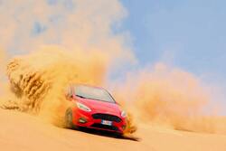 Red Ford Driving on Sand